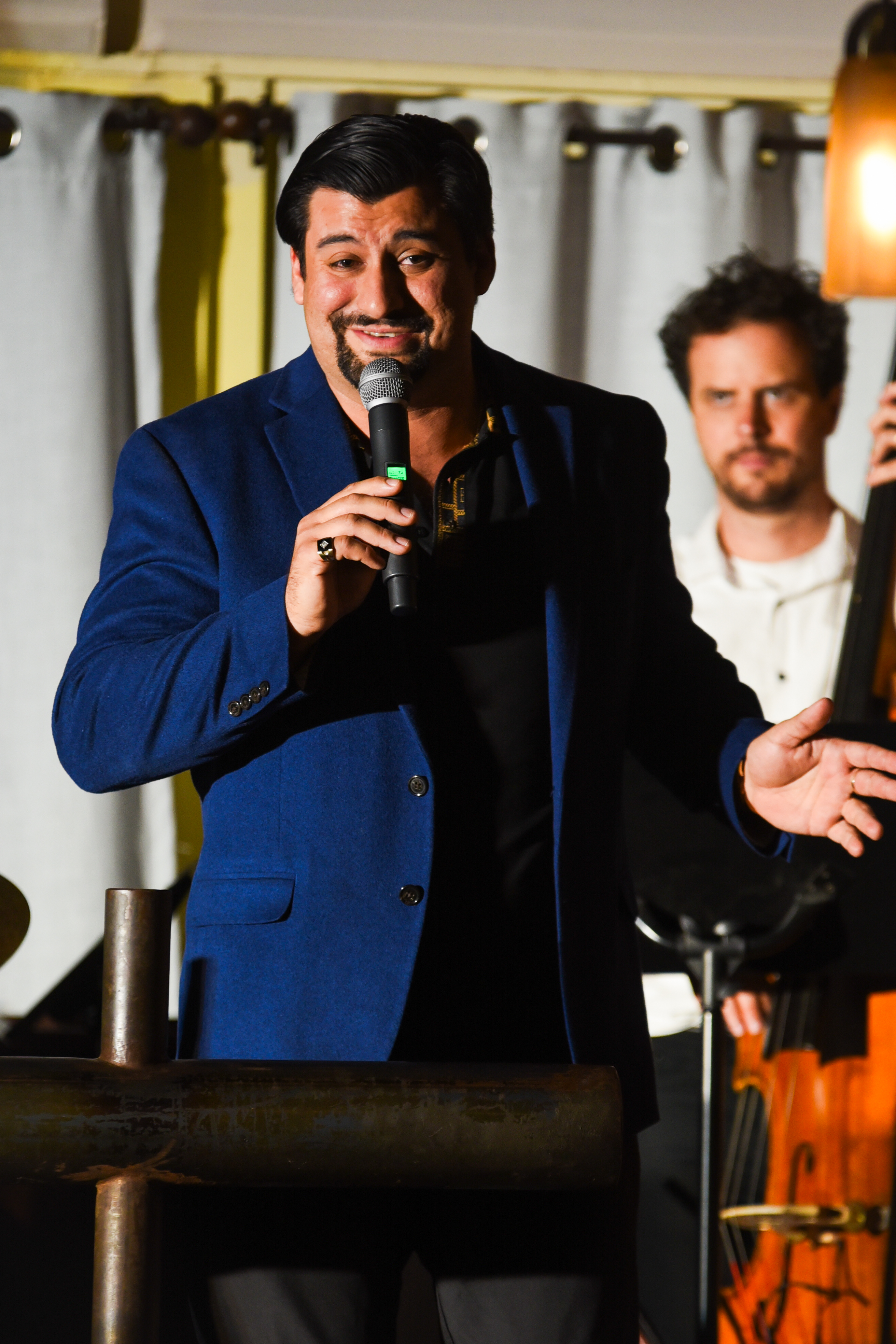 Close-up of host performing with bassist